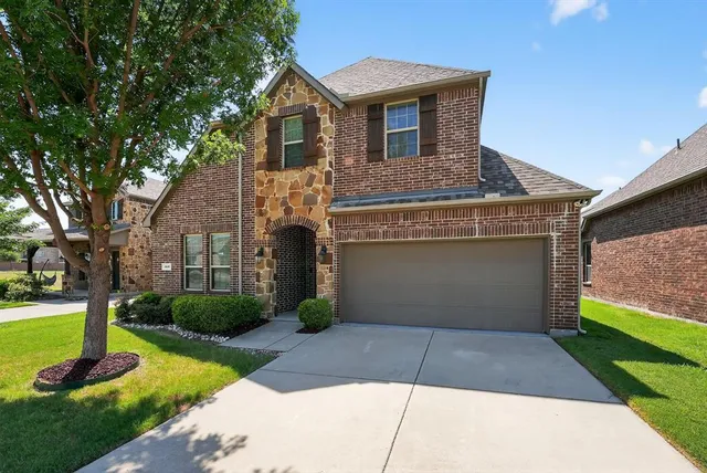 a front view of a house with a garden and plants