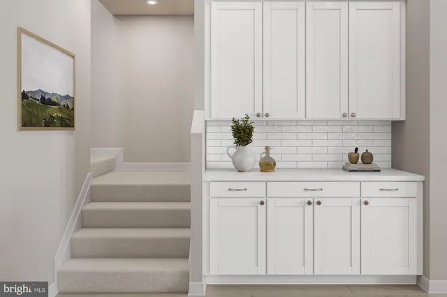 a kitchen with white cabinets and sink