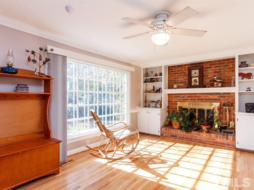 5704 Setter Circle Raleigh, NC 27609 - Photo 13 of 25 a living room with furniture a fireplace and a floor to ceiling window