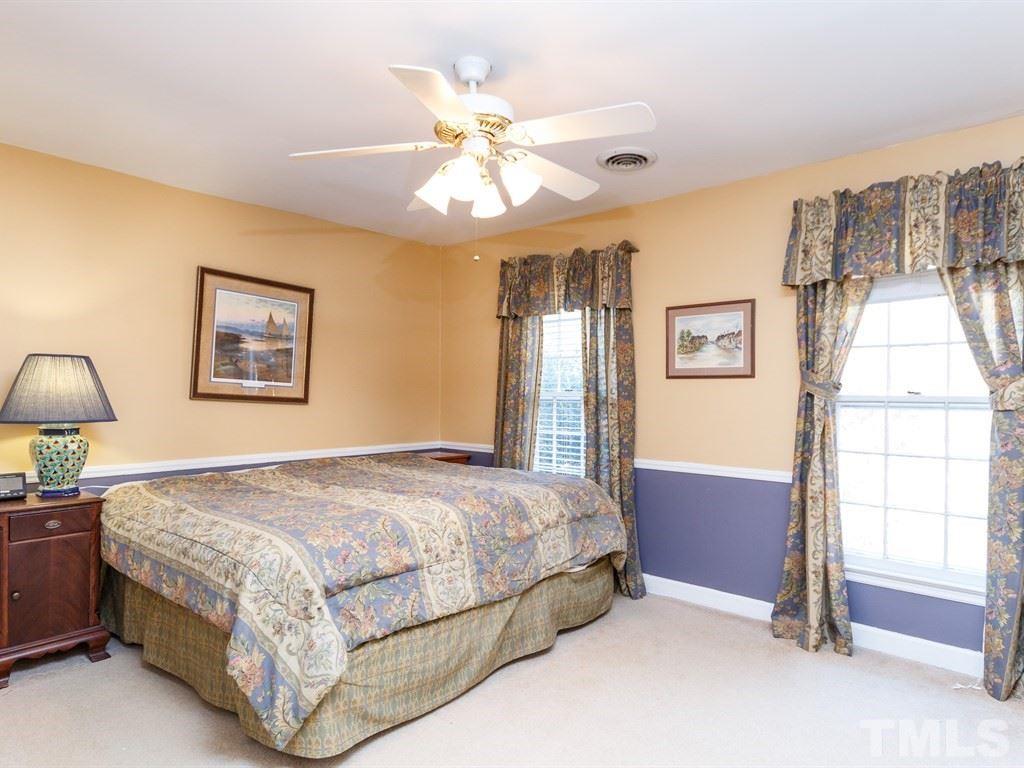 5704 Setter Circle Raleigh, NC 27609 - Photo 20 of 25 a bedroom with a bed and a chandelier