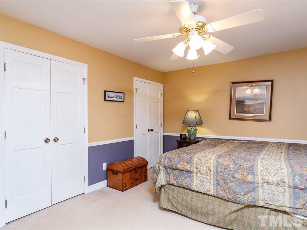5704 Setter Circle Raleigh, NC 27609 - Photo 21 of 25 a bedroom with a bed and a chandelier