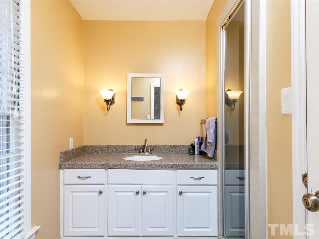 5704 Setter Circle Raleigh, NC 27609 - Photo 22 of 25 a bathroom with a granite countertop sink and a mirror