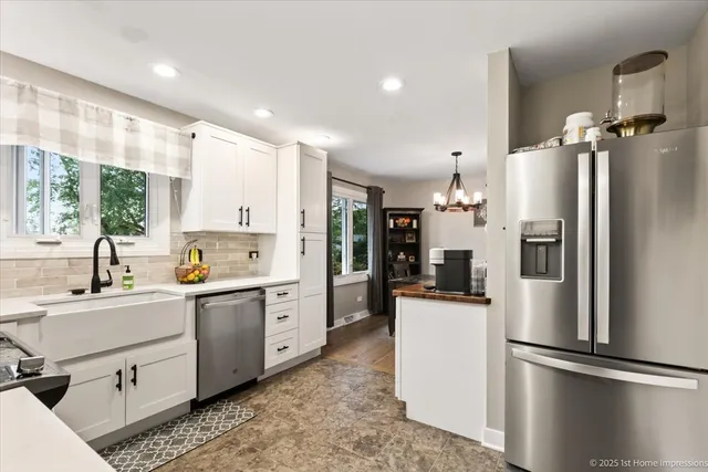 a kitchen with white cabinets and stainless steel appliances
