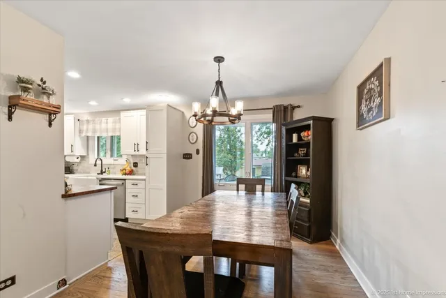 a dining room with stainless steel appliances kitchen island a table and chairs