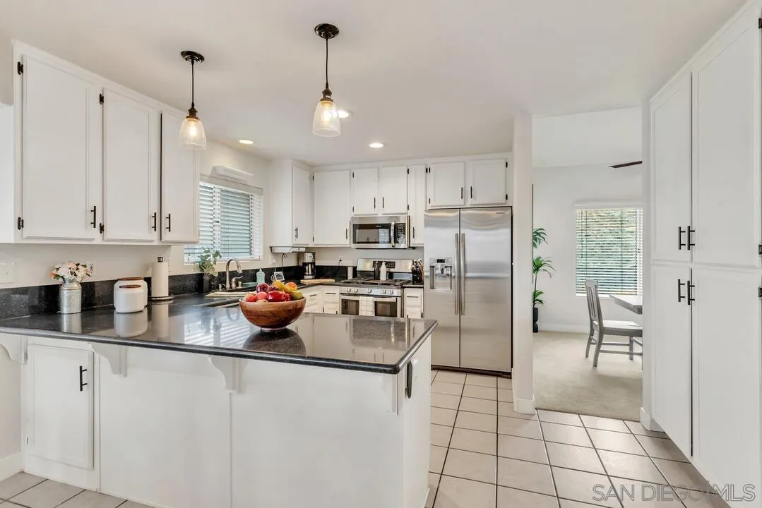 9410 Brian Way El Cajon, CA 92021 - Photo 12 of 49 a kitchen with stainless steel appliances granite countertop a refrigerator a sink a stove and white cabinets