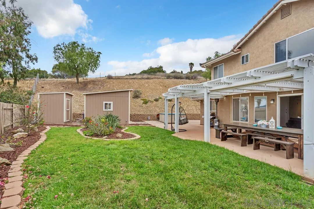9410 Brian Way El Cajon, CA 92021 - Photo 21 of 49 a front view of house with a garden and patio