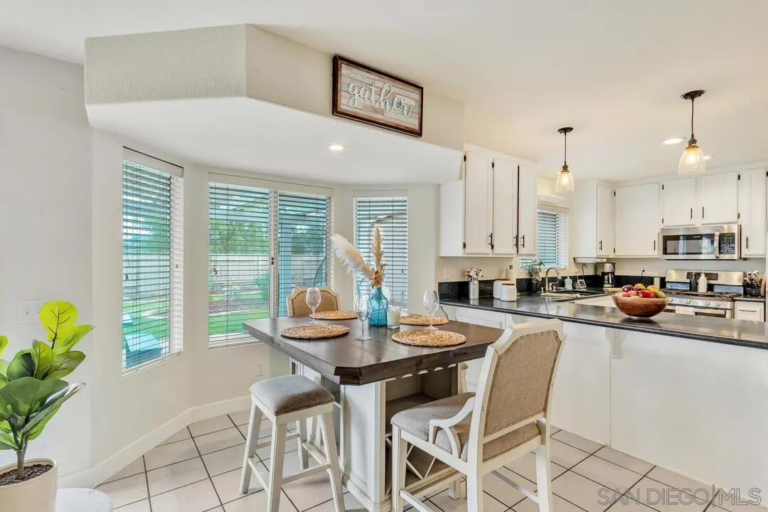9410 Brian Way El Cajon, CA 92021 - Photo 24 of 49 a kitchen with stainless steel appliances kitchen island granite countertop a table and chairs in it