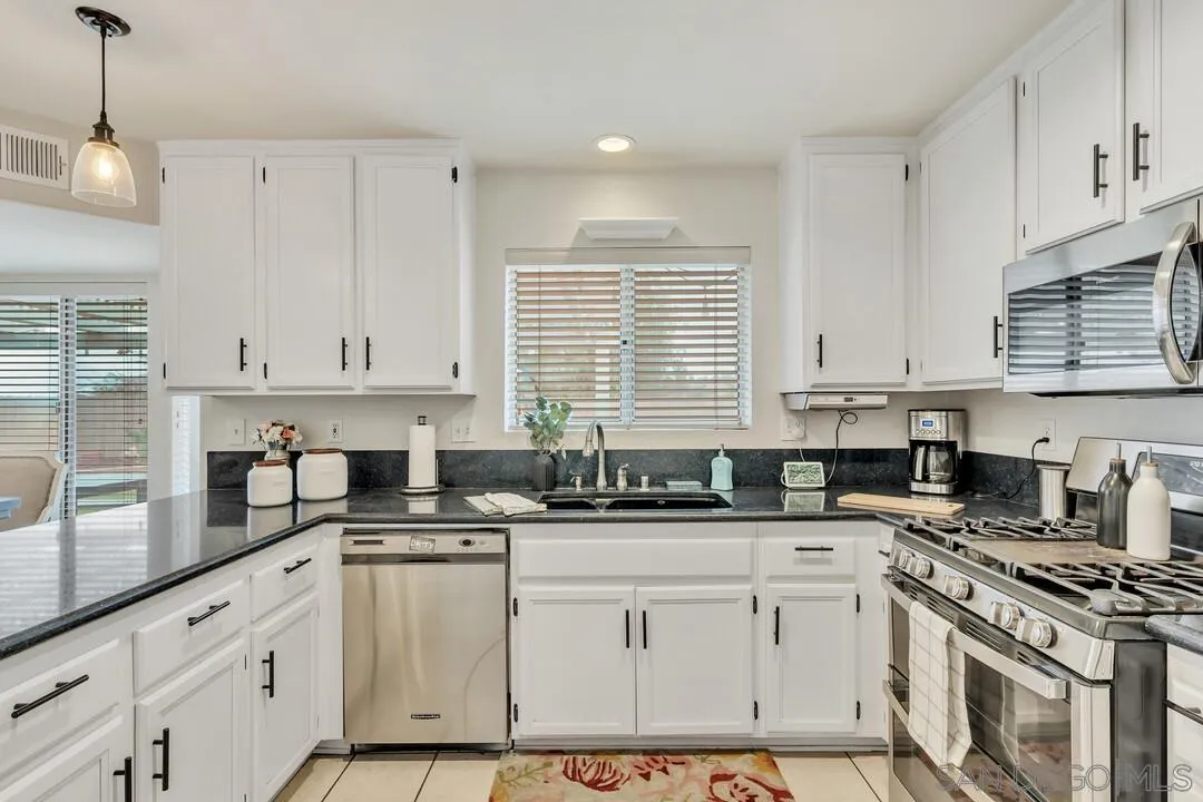 9410 Brian Way El Cajon, CA 92021 - Photo 26 of 49 a kitchen with granite countertop a sink a stove and cabinets