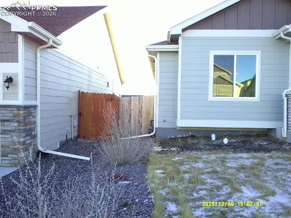 a view of a backyard with plants and brick wall