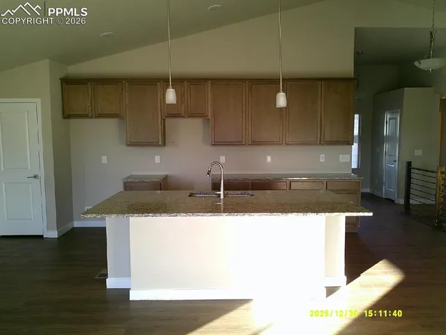 a kitchen with a sink a refrigerator and cabinets