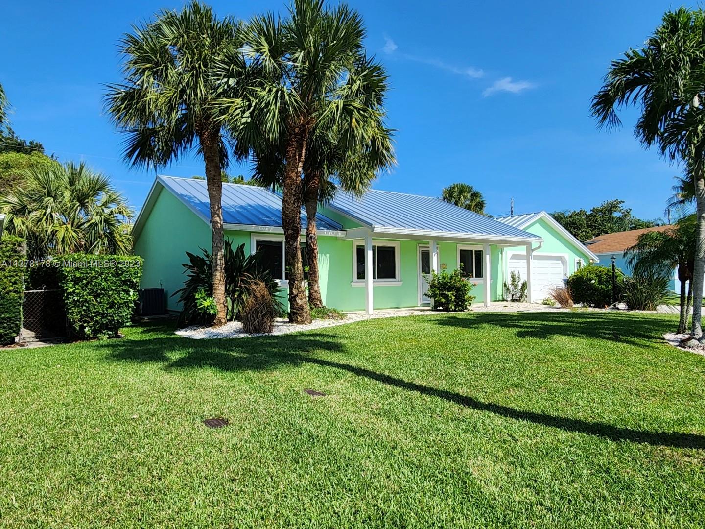 1513 Lance Road Jupiter, FL 33469 - Photo 1 of 33 a front view of a house with a garden and trees