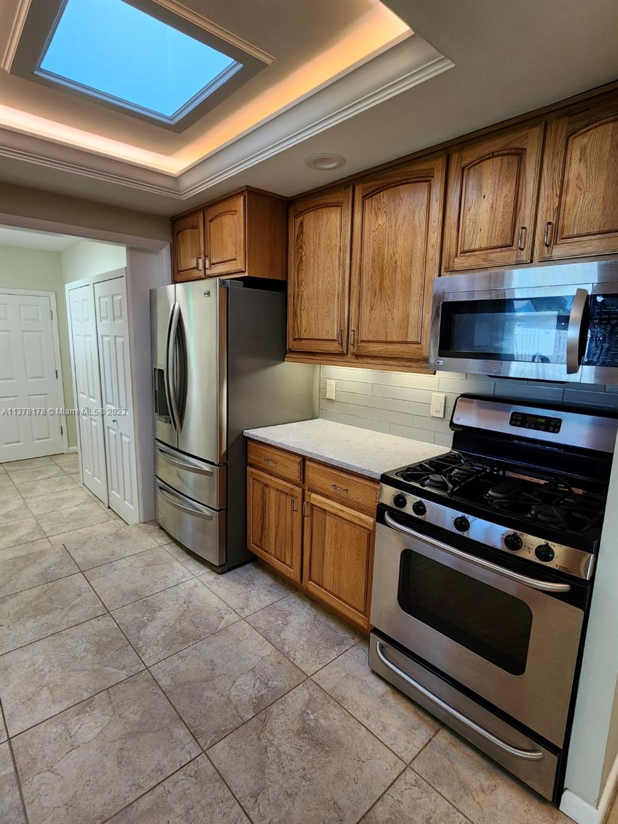 1513 Lance Road Jupiter, FL 33469 - Photo 12 of 33 a kitchen with granite countertop a stove and a refrigerator