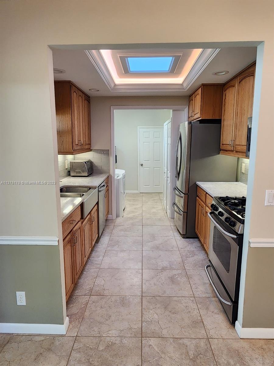 1513 Lance Road Jupiter, FL 33469 - Photo 14 of 33 a kitchen with stainless steel appliances granite countertop a stove and a refrigerator