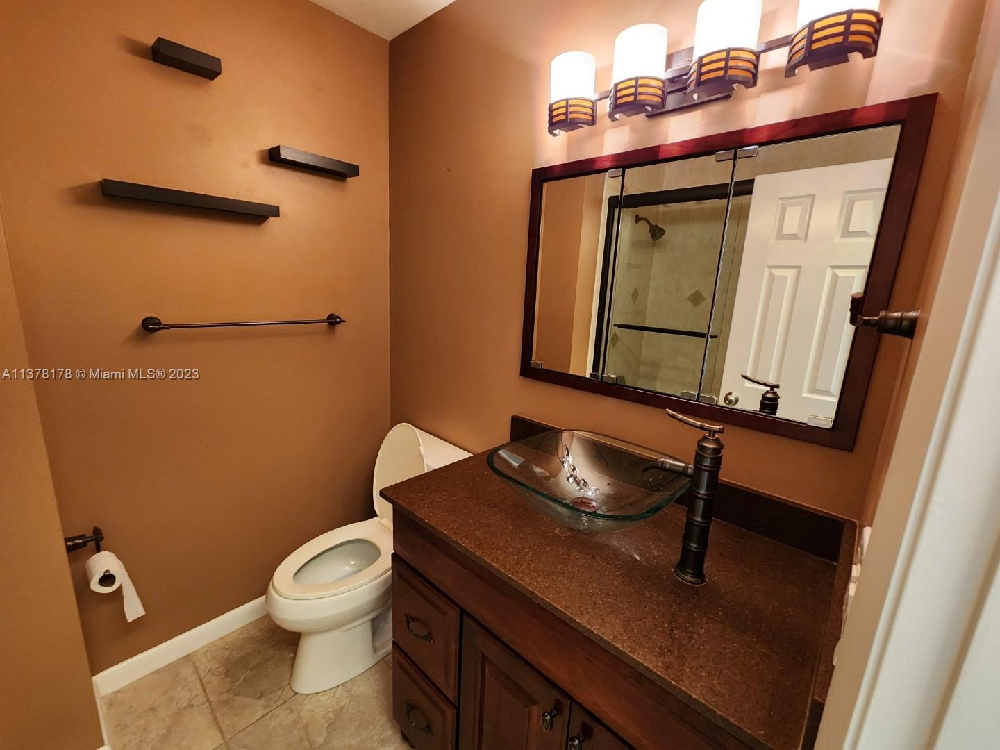 1513 Lance Road Jupiter, FL 33469 - Photo 28 of 33 a bathroom with a toilet sink and mirror