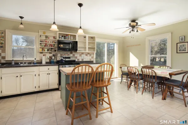 a kitchen with granite countertop a sink dining table and chairs