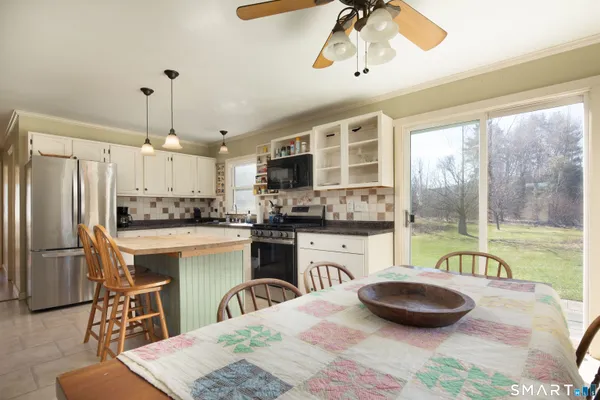 a kitchen with a table chairs refrigerator and cabinets