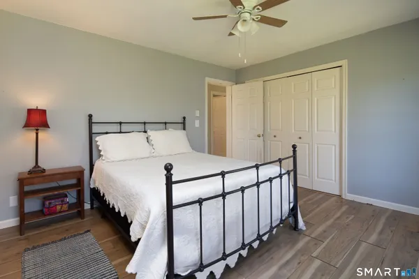 a bedroom with bed and wooden floor