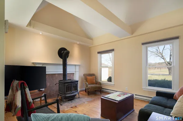 a living room with furniture a flat screen tv and a window