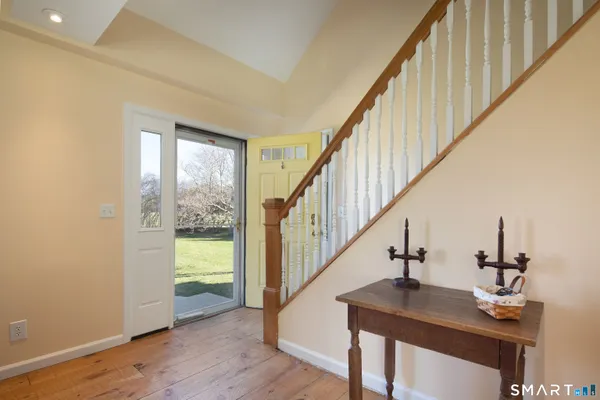 a view of entryway and hall with wooden floor