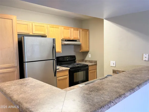 a kitchen with granite countertop a refrigerator stove top oven and sink