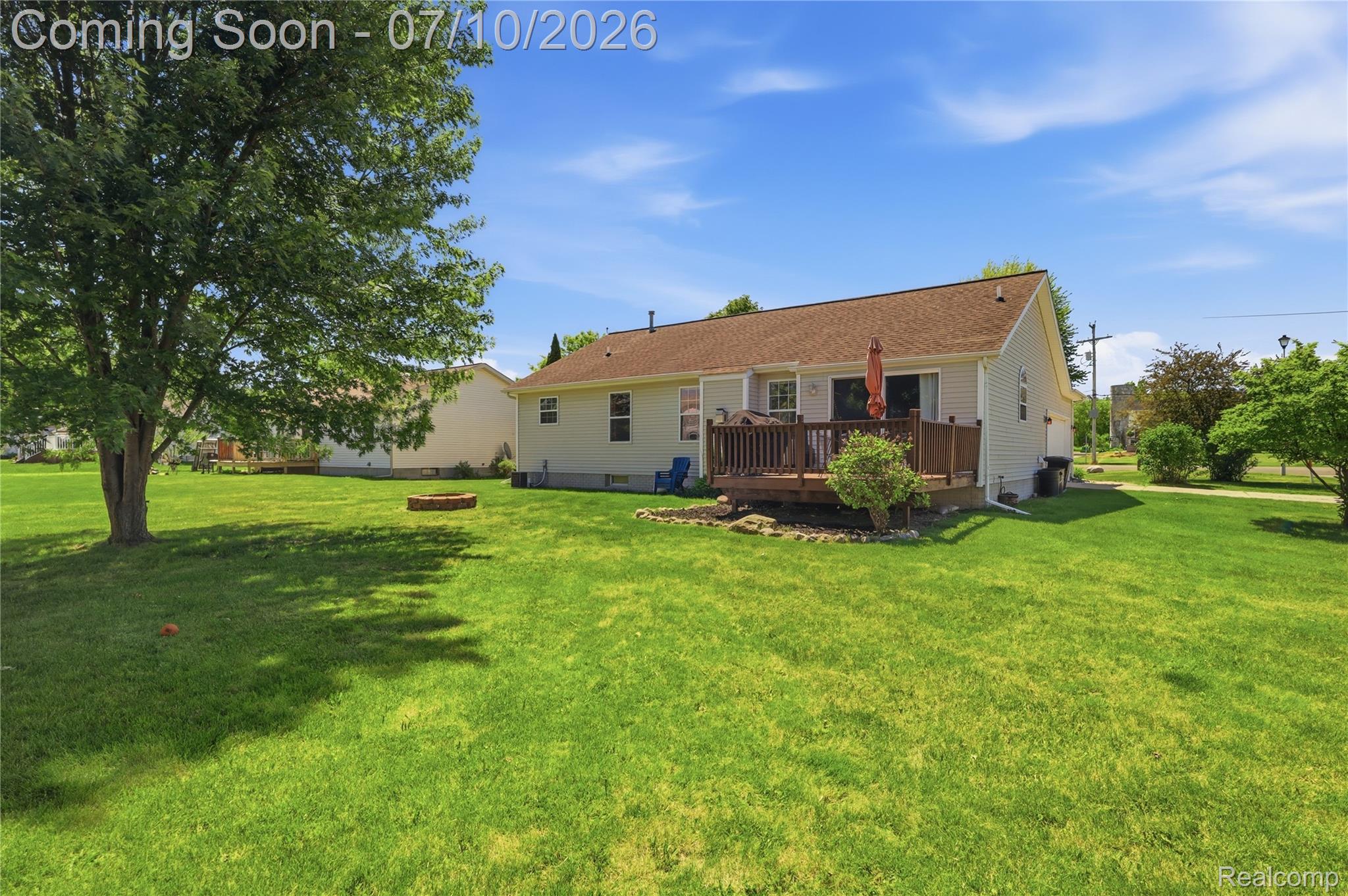 5275 East Maple Avenue Grand Blanc, MI 48439 - Photo 6 of 53 Expansive backyard featuring a wood deck, mature shade tree, and a fire pit area