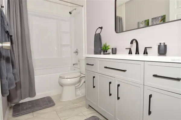 a bedroom with a bed and a flat tv screen on dresser