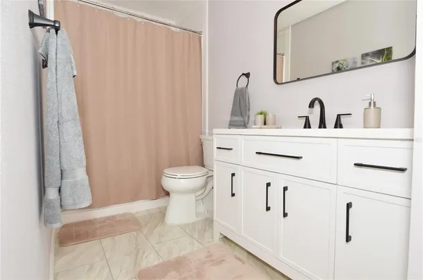 a view of a dining room with furniture large windows and wooden chandelier