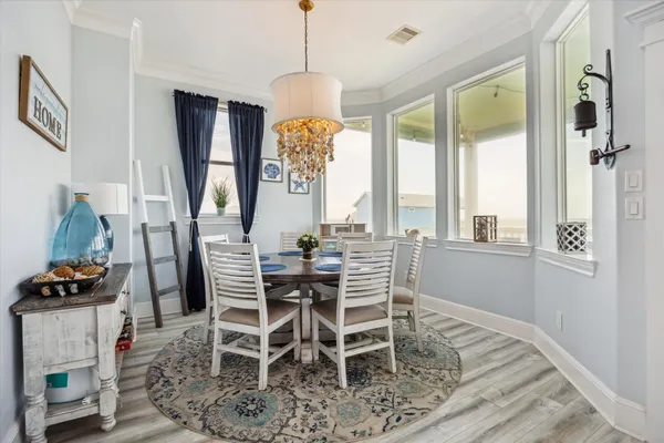 a dining room with furniture a chandelier and wooden floor