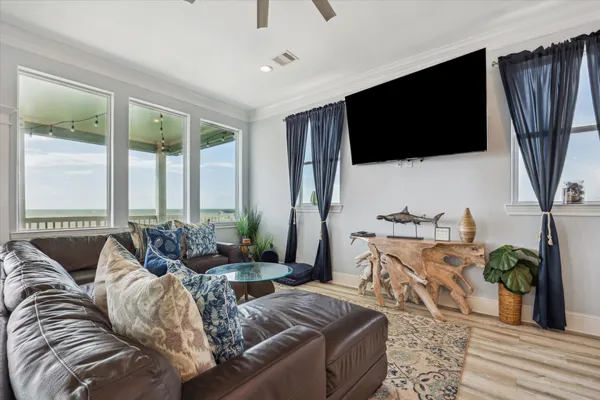 a living room with furniture a flat screen tv and a floor to ceiling window