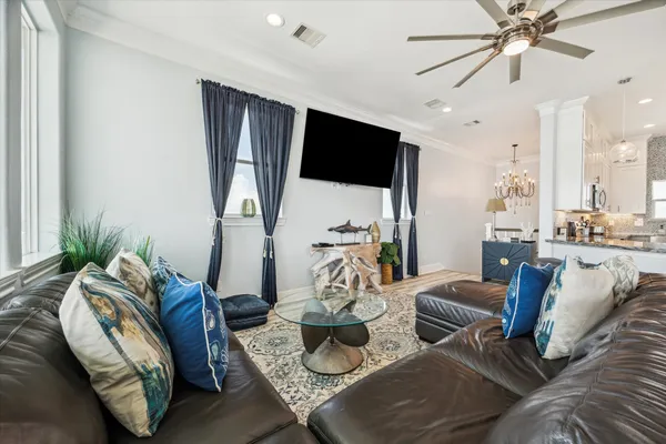 a living room with furniture a flat screen tv and a large window