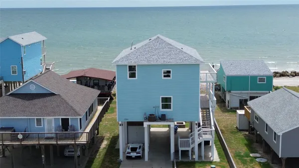 an aerial view of a house with outdoor seating