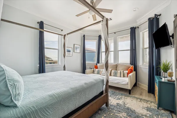 a bedroom with a bed couch and a flat tv screen