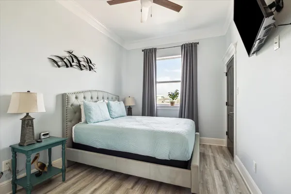 a bedroom with a bed a mirror on dresser and a window