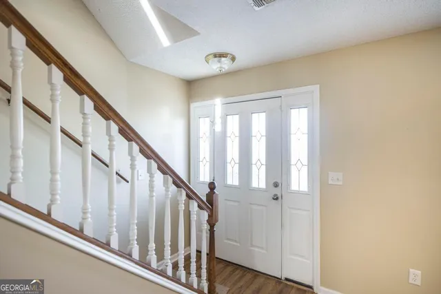 a view of staircase with wooden floor and white walls