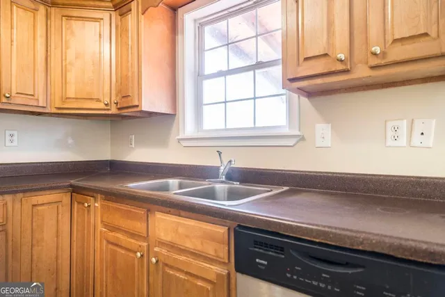 a kitchen with stainless steel appliances granite countertop white cabinets and a sink
