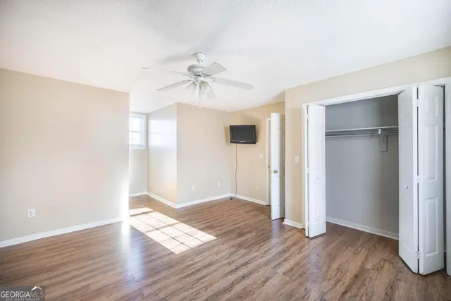 a view of an empty room with wooden floor