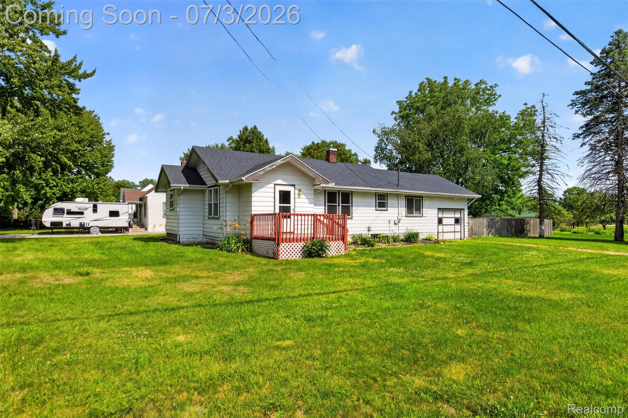 4322 Baker Road Bridgeport, MI 48722 - Photo 1 of 29 White siding home featuring a red-painted front deck, attached garage with a panel door, and dark shingle roofing