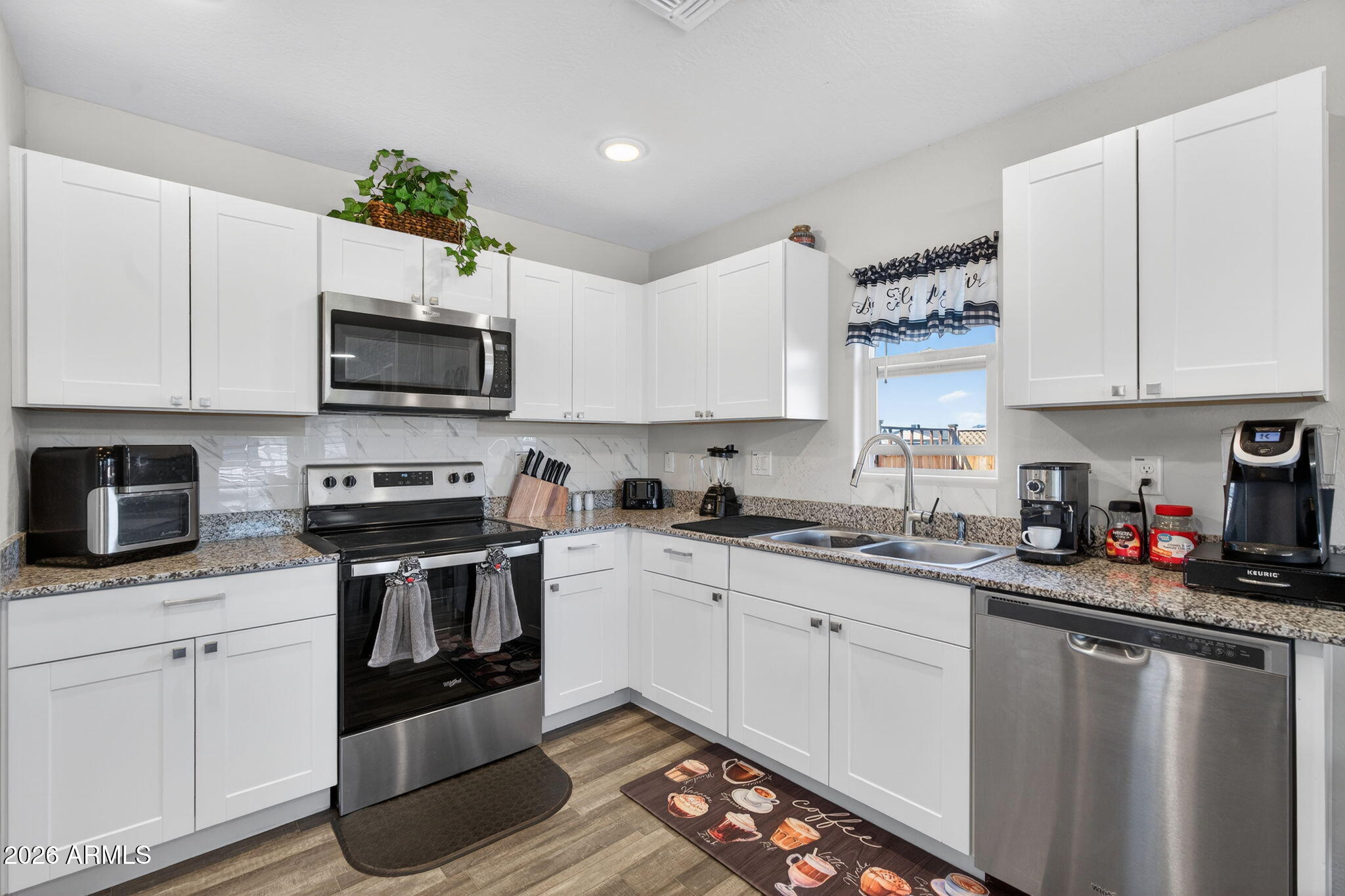 14423 South Capistrano Road Arizona City, AZ 85123 - Photo 14 of 36 a kitchen with granite countertop a sink cabinets and stainless steel appliances