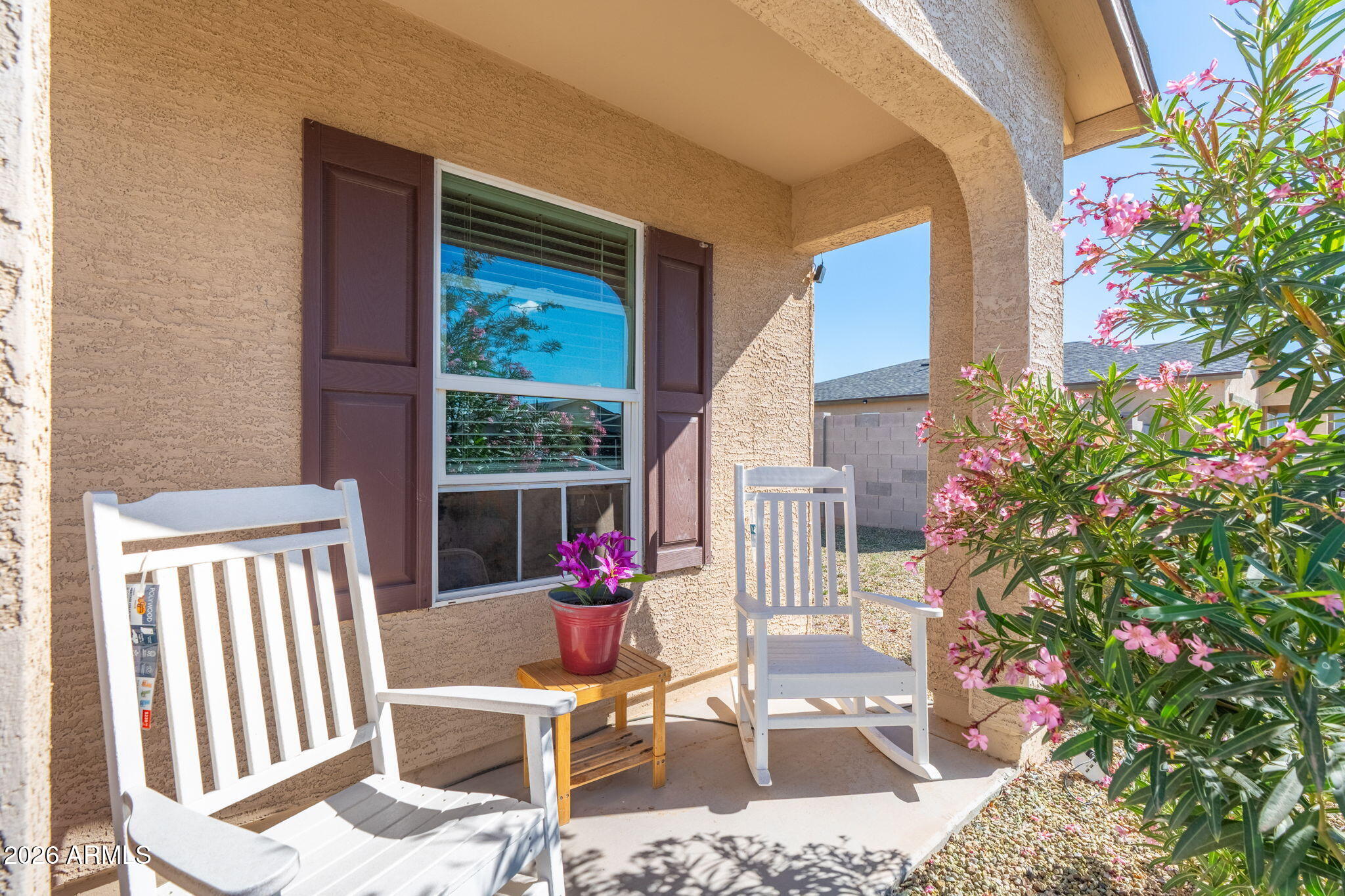 14423 South Capistrano Road Arizona City, AZ 85123 - Photo 3 of 36 a porch area with flowers in front of it
