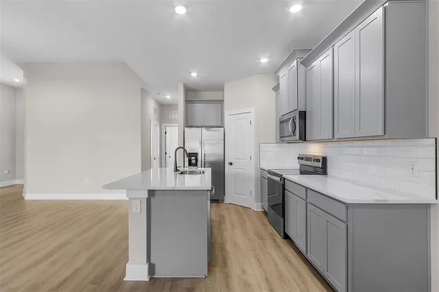 a kitchen with stainless steel appliances kitchen island granite countertop a refrigerator sink and cabinets