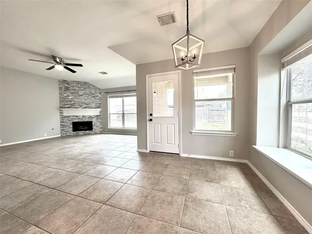 a view of an empty room with a window and fire place