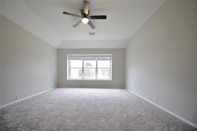 a view of a big room with windows and chandelier fan