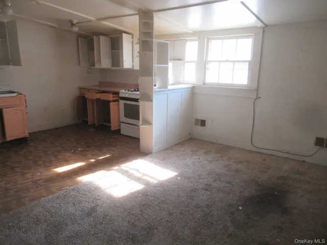 an empty room with a ceiling fan and glass door