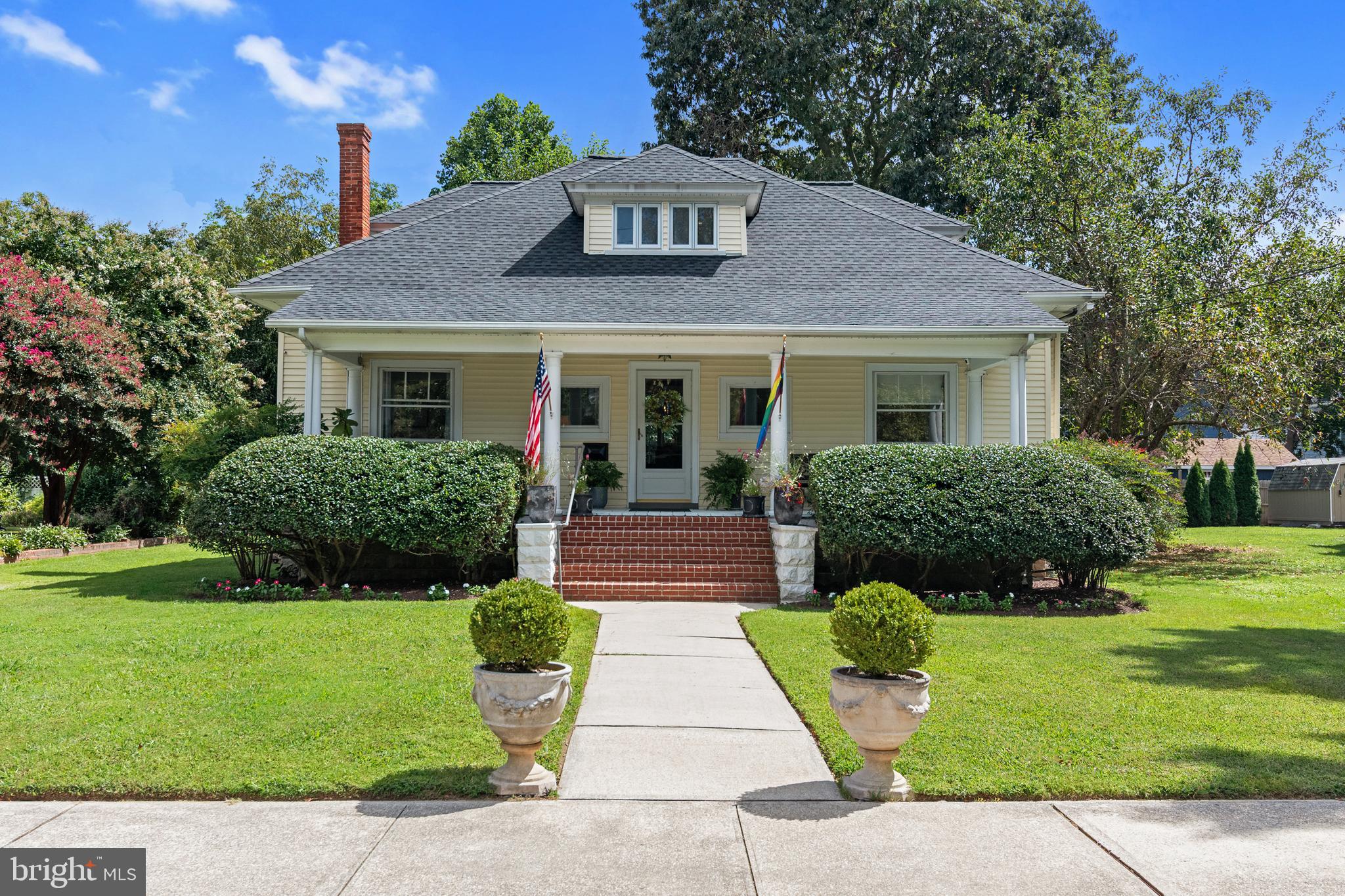 306 Oakley Street Cambridge, MD 21613 - Photo 2 of 35 a front view of a house with a garden