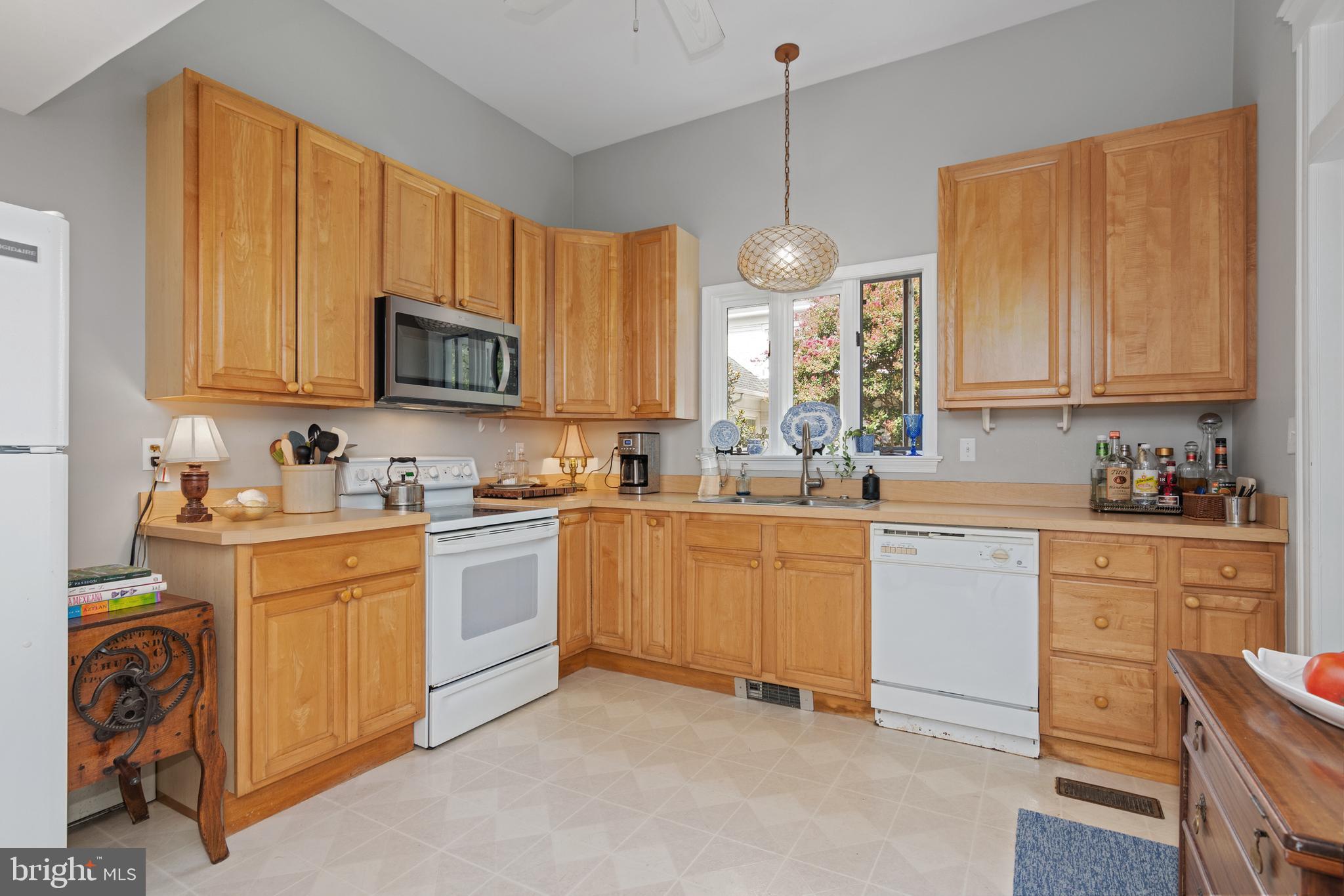 306 Oakley Street Cambridge, MD 21613 - Photo 24 of 35 a kitchen with kitchen island granite countertop a sink cabinets stainless steel appliances and a window