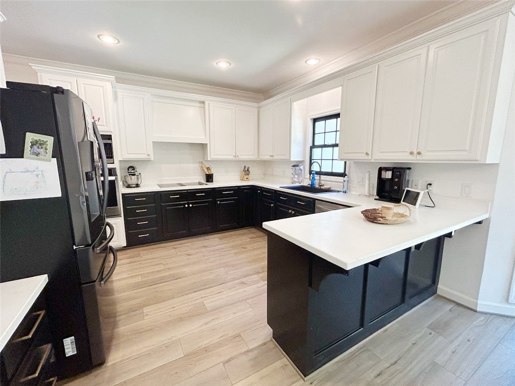 2004 Moores Mill Road Lanett, AL 36863 - Photo 24 of 50 This modern kitchen features a spacious layout with white countertops and light-colored flooring.