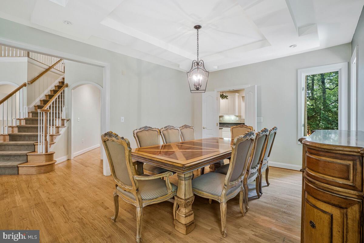 502 Seneca Knoll Court Great Falls, VA 22066 - Photo 14 of 56 a dining room with furniture a chandelier and wooden floor