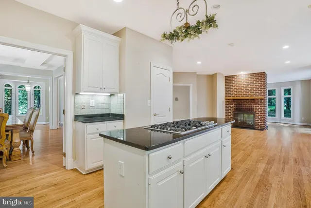 a kitchen with stainless steel appliances granite countertop a sink cabinets and wooden floor