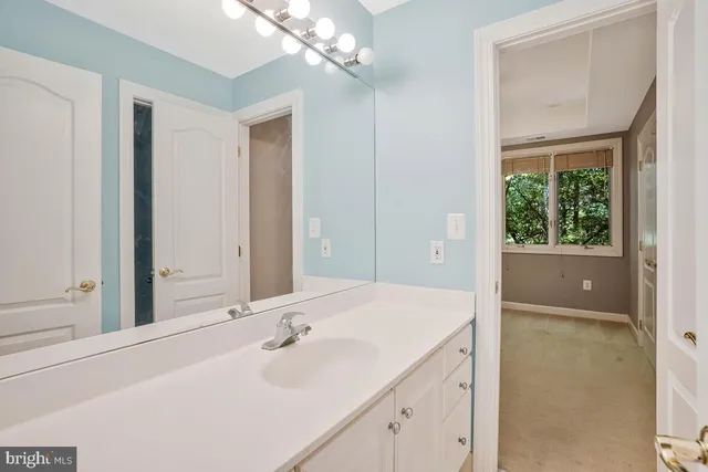 a bathroom with a bathtub a sink a vanity a lamp and a mirror