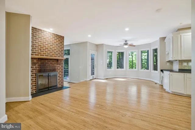 an empty room with windows and chandelier fan